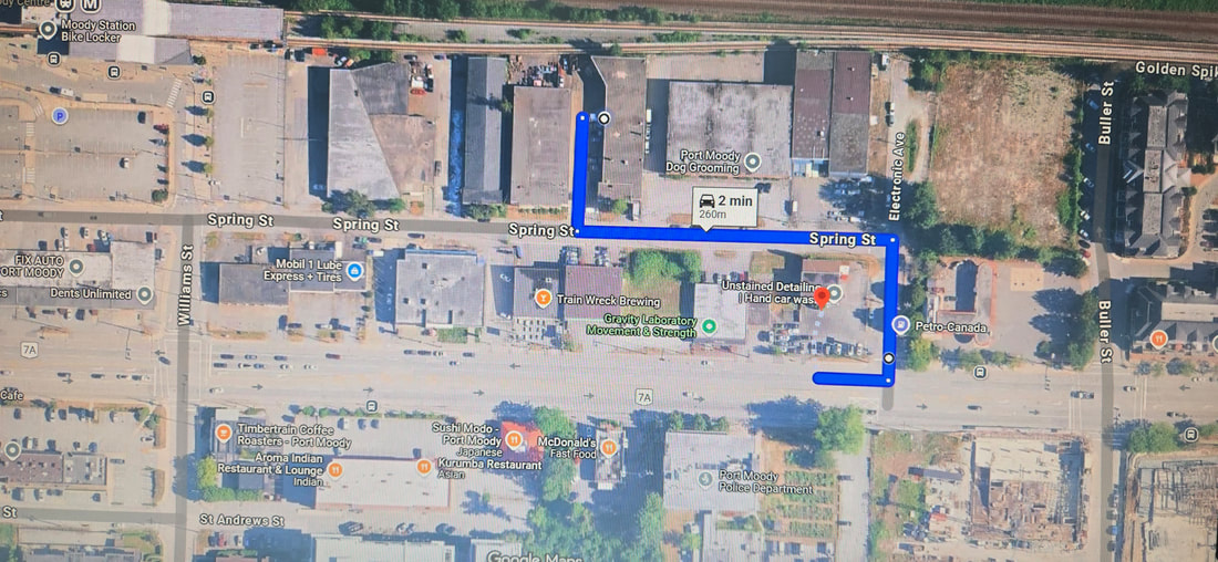 Aerial map view of Port Moody showing a blue route marker along Spring Street indicating a 2-minute travel time to Candy Autobody Inc.