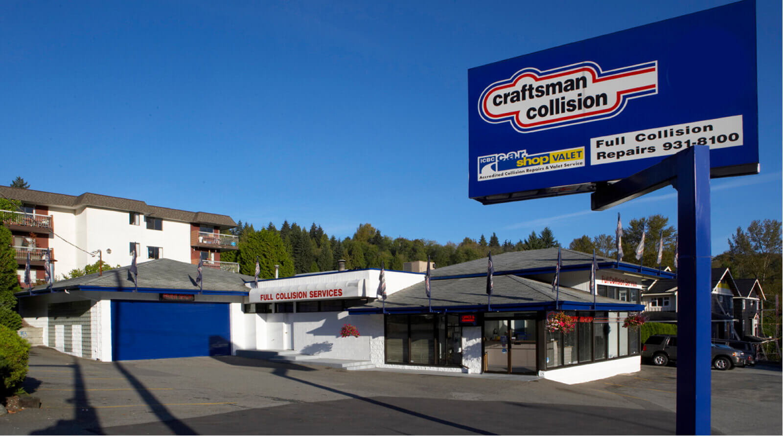 Craftsman Collision repair shop in Port Moody with blue and white storefront and large blue signage advertising full collision repairs