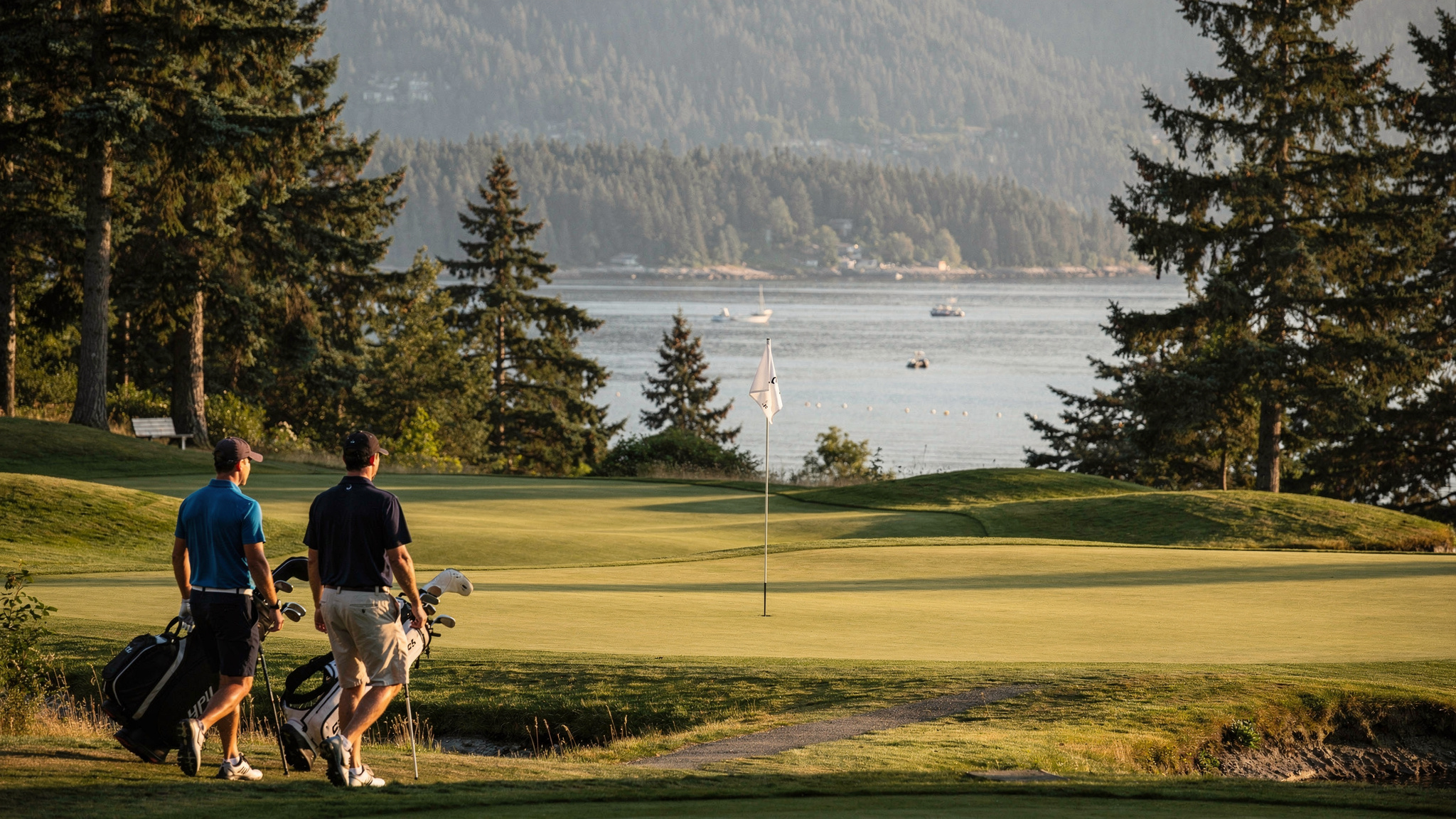Golfers walking toward the green overlooking Port Moody's Burrard Inlet