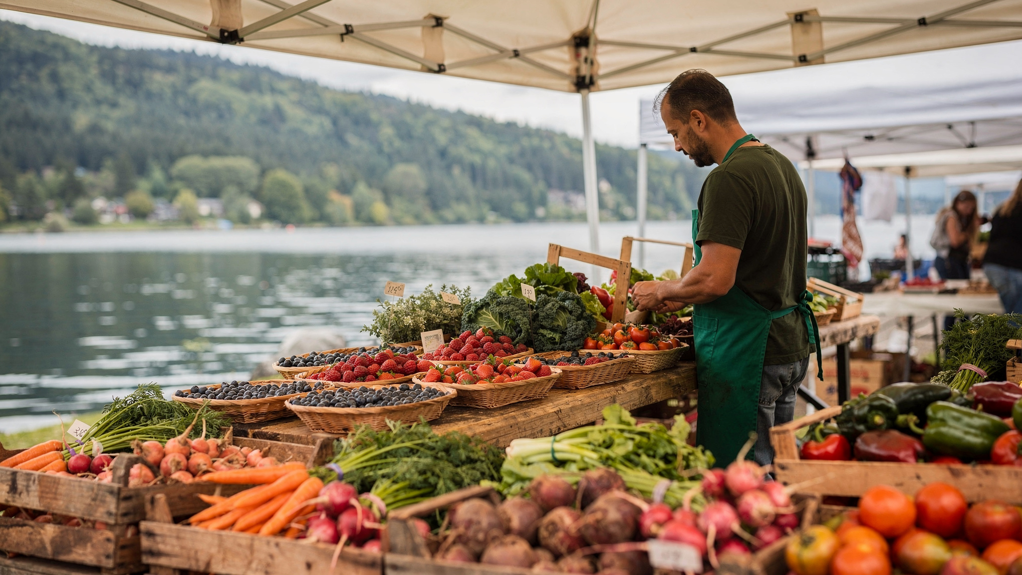 Farmers market vendor arranging baskets of berries and vegetables at a Port Moody waterfront stall