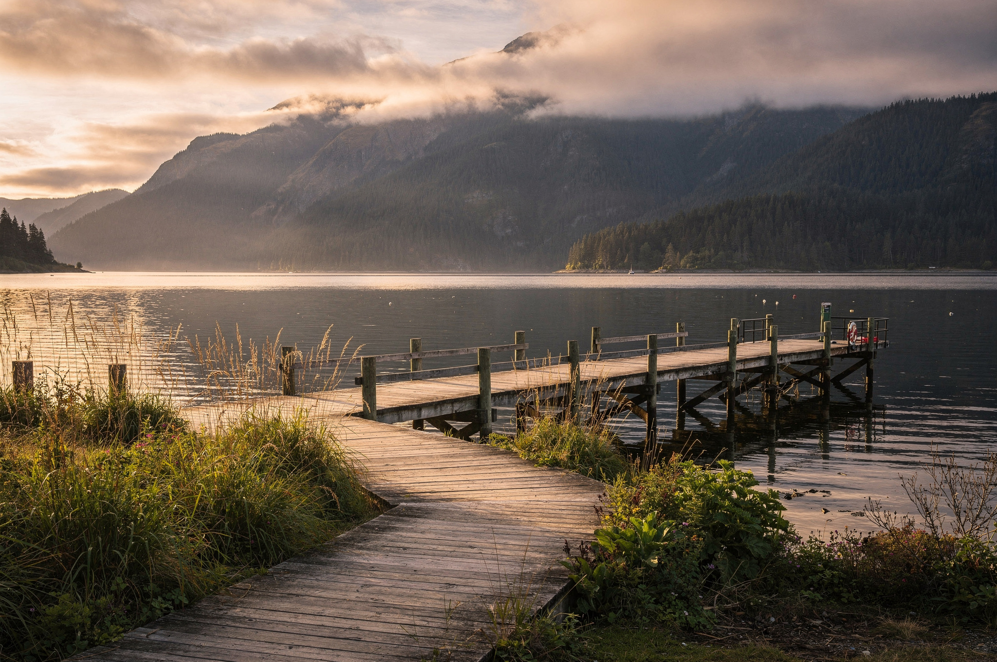 Wooden pier on a calm inlet with mountains in Port Moody